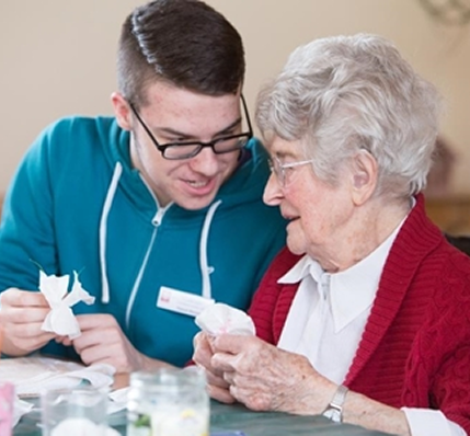 Jugendlicher betreut in seinem FSJ eine Seniorin