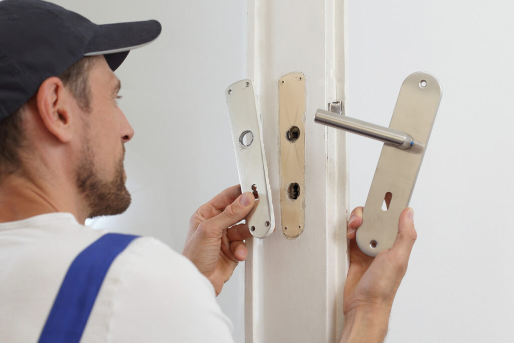 Handwerker repariert kaputte Türklinke